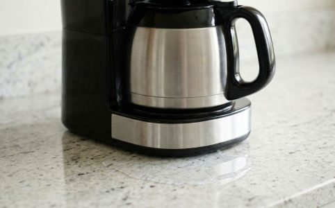 Coffee maker leaking water from the bottom onto a kitchen counter