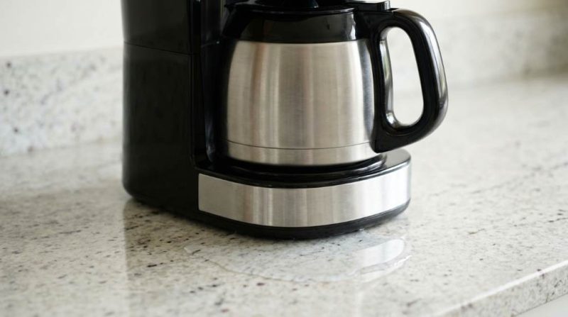 Coffee maker leaking water from the bottom onto a kitchen counter