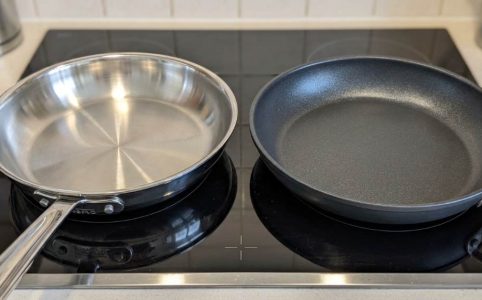 Stainless steel pan and nonstick pan placed side by side on a kitchen counter