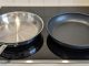 Stainless steel pan and nonstick pan placed side by side on a kitchen counter