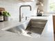 Sparkling stainless steel kitchen sink shining under bright natural light.