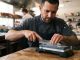 Male chef carefully sharpening high carbon chef knife using dual grit whetstone.